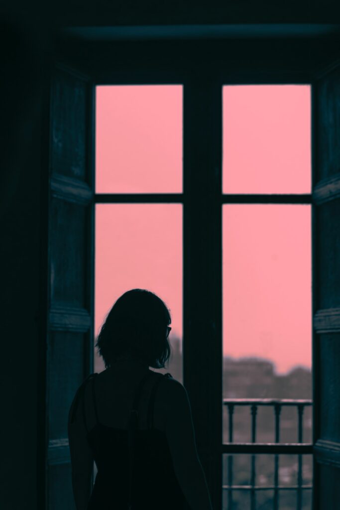 夕暮れ窓辺の女性